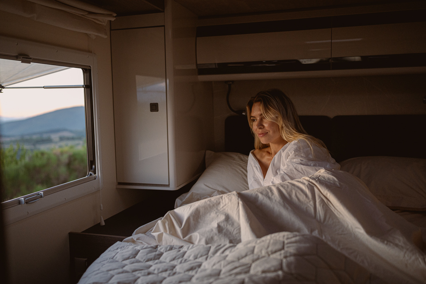 Interno di un camper Arca con vista panoramica dal letto
