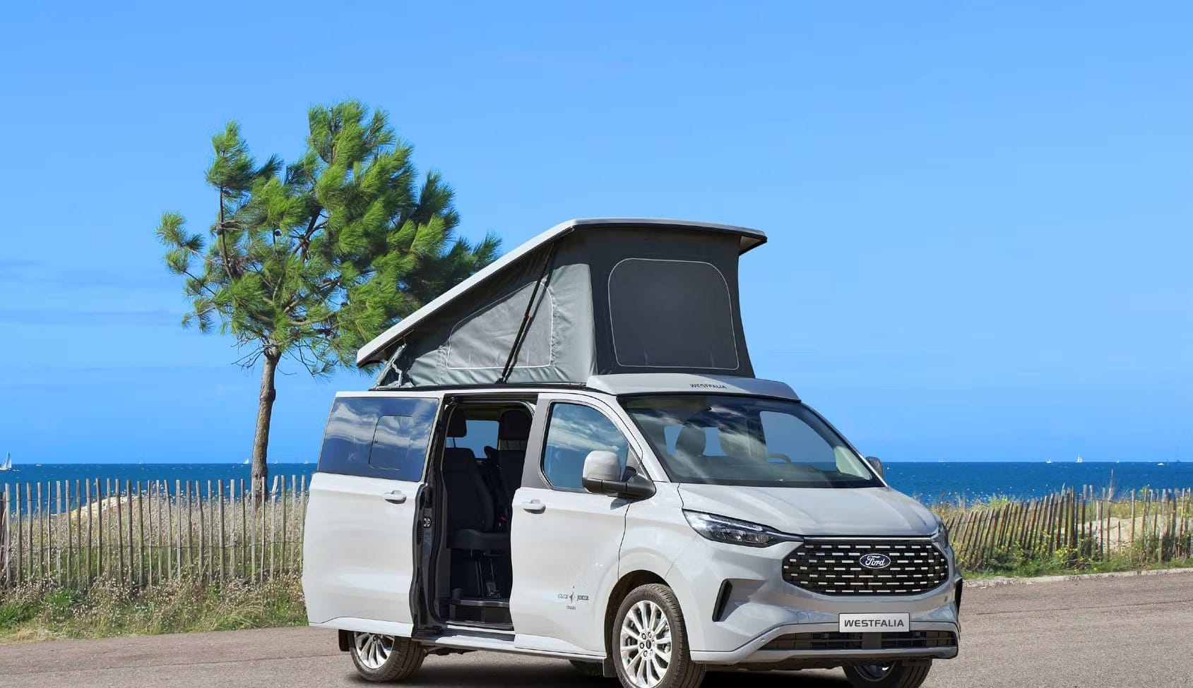 Westfalia bianco con tetto aperto al mare